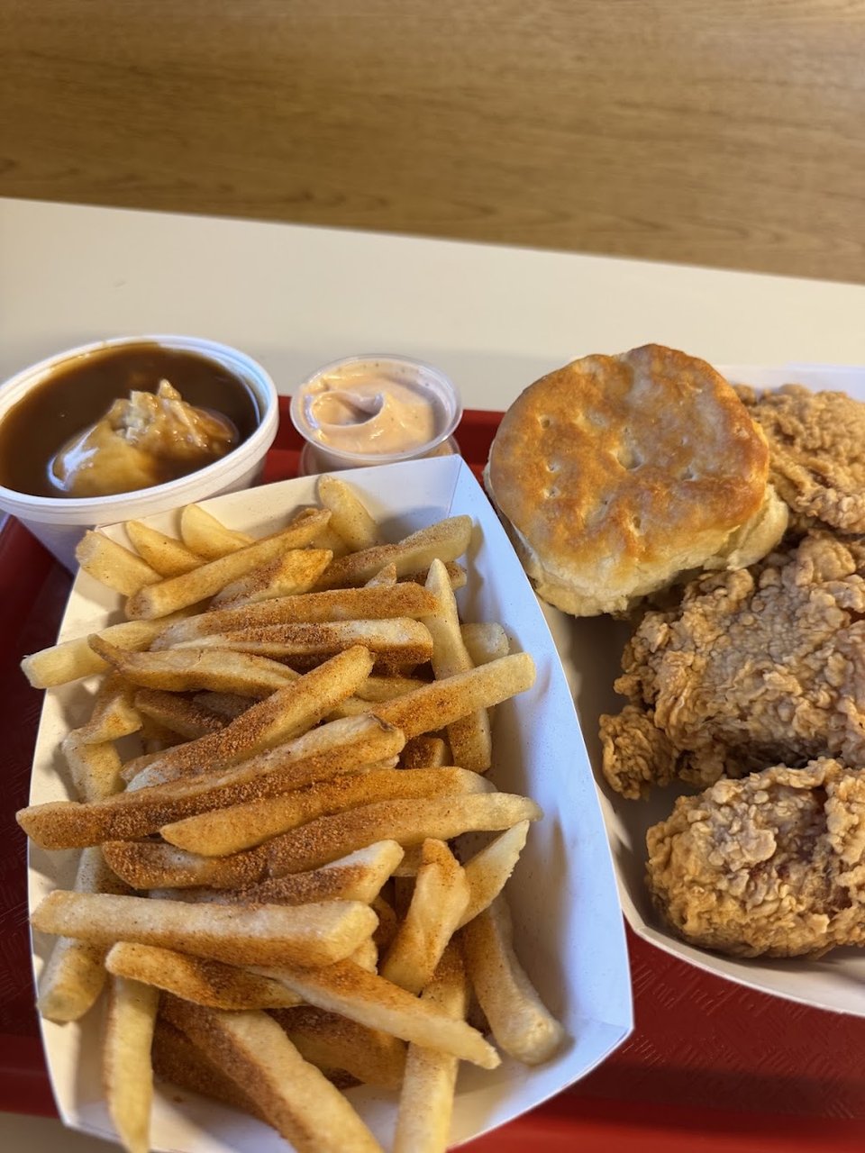 Chicken tenders and sides on a takeaway tray.